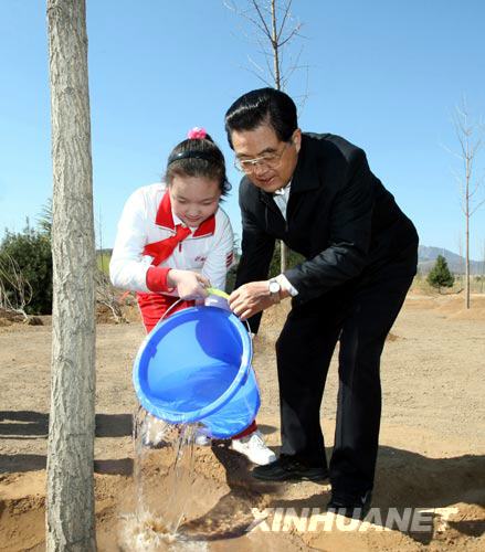  4月5日，党和国家领导人胡锦涛、吴邦国、温家宝、贾庆林、习近平、李克强、贺国强、周永康来到北京永定河森林公园参加首都义务植树活动。这是胡锦涛同少先队员一起给刚栽下的银杏树浇水。(