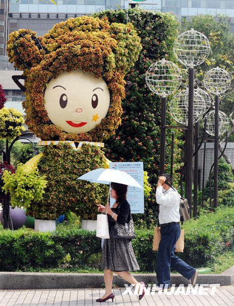     6月8日，人们从一座约4米高的“花精灵”绿雕旁走过。 