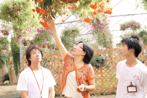 夏雨正在花园里给员工讲养花技巧。