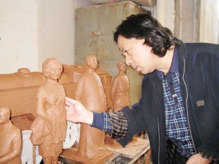 李春华正对南海名人系列泥稿做最后的修饰。