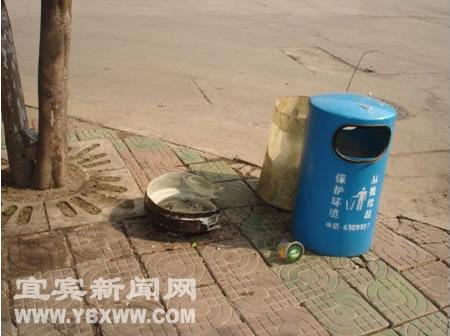 图为新安装的环保果皮箱，箱体底座被人为损坏。 