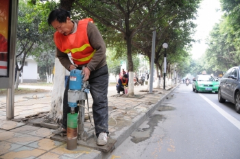 北湖路上，工人正在为安装护栏钻孔 