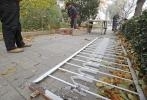 图为工人正在处理被毁围栏
