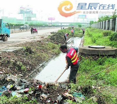 改造中的沟渠内清出的垃圾污物堆成小山