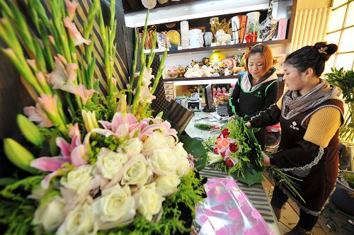 11月11日，在宁夏银川一家花店内，工作人员在包装顾客预订的鲜花。