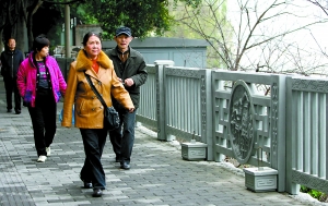 嘉滨路黄花园轻轨站旁，市民在新修复的人行步道上散步。