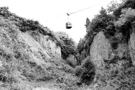 山路崎岖，李书邦在山间架起了钢索运送物品