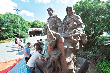 图为昨天下午，作者张飙和工作人员为雕塑做最后的清洗工作。