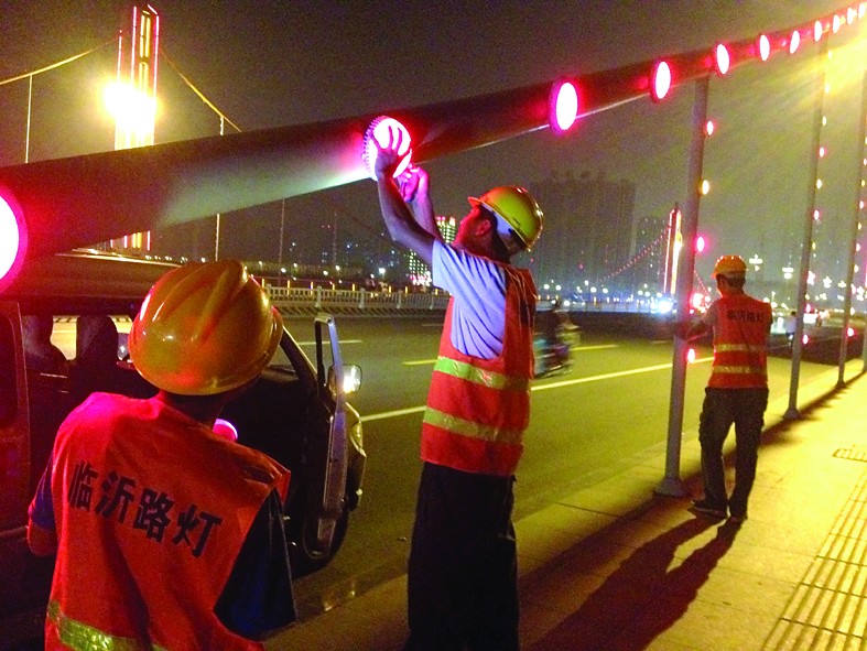 市路灯处维修人员正在维修金锣大桥LED壁灯。