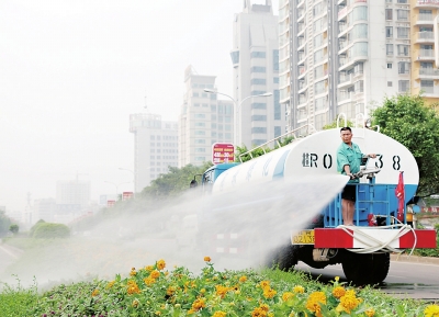 洒水车对中山北路广场段的道路绿地进行喷淋。