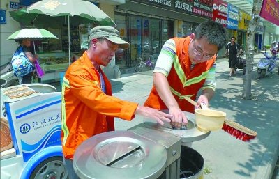 记者在高温下认真清洗垃圾桶体验环卫工作