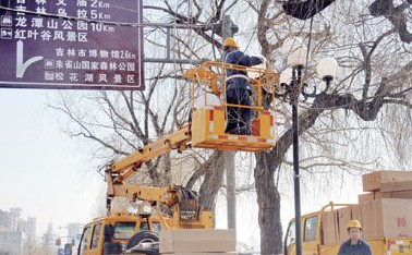 在松江中路，路灯管理处的工作人员更换路灯灯罩。