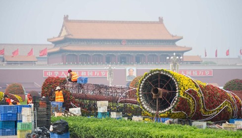 工人在北京天安门广场西侧绿化带摆花